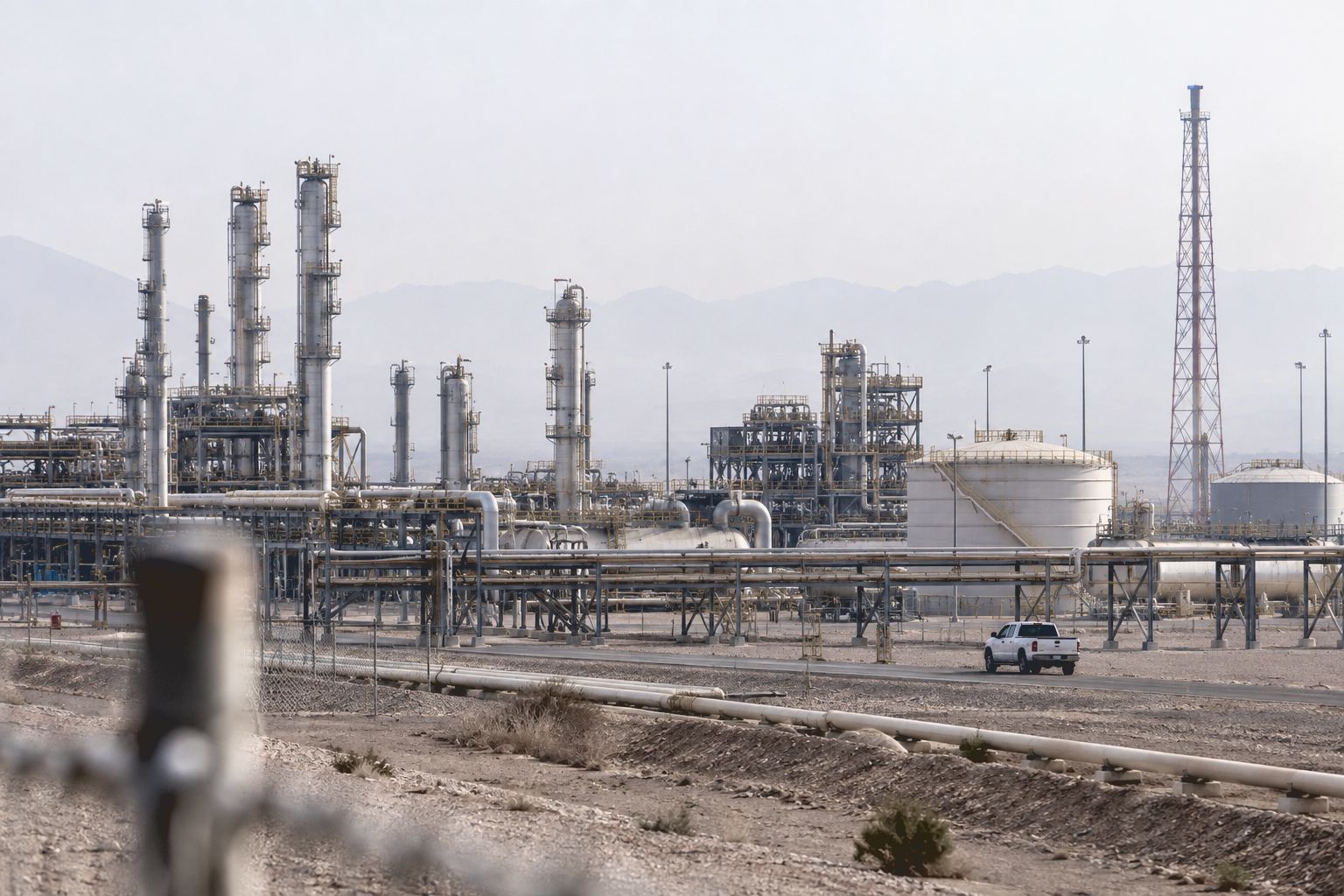 A gas plant in a hazy desert landscape