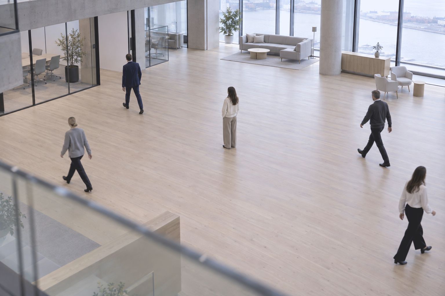 People crossing a wide open office floor, seen from above
